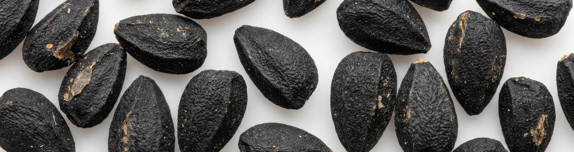 Black seeds arranged across a light surface